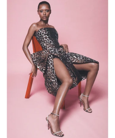 Sophie Wilde seated on an orange chair wearing a leopard print strapless dress for Vogue Australia October 2026