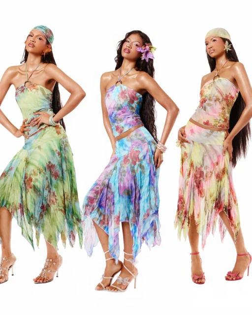 Three women pose in halter tops and skirts with floral print on a white background, accessorized with jewelry and hair accessories.