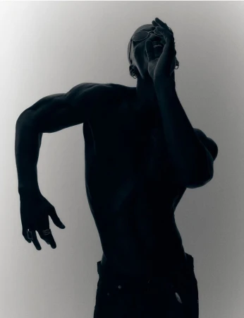 Silhouette of a shirtless man posing dramatically with one hand near his face against a white seamless background