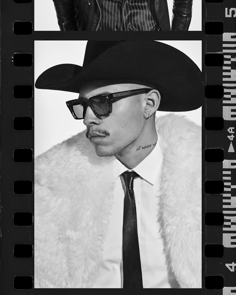 Monochrome portrait of a man in sunglasses and a cowboy hat, posing in a faux fur coat against a white backdrop with filmstrip border.
