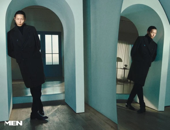Model Xu Meen wearing a dark coat leaning against an arched architectural partition for Noblesse Korea by Sungjae Oh