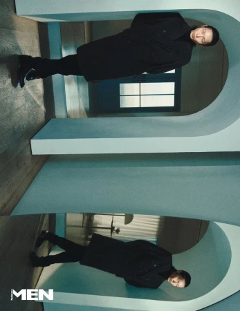 Model Xu Meen wearing a dark coat standing inside an architectural hallway with arched structural dividers.