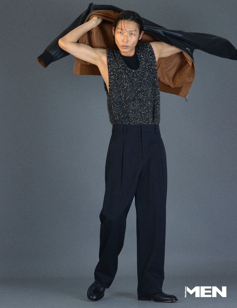 Model Xu Meen holding a leather jacket over shoulders against a grey studio backdrop for Noblesse Korea editorial