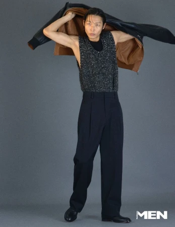 Model Xu Meen holding a leather jacket over shoulders against a grey studio backdrop for Noblesse Korea editorial