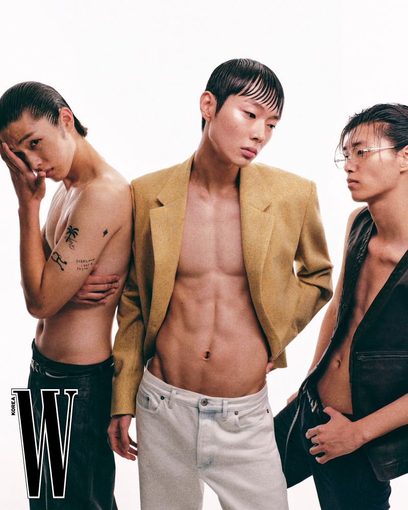 Three male models posing together against a plain white studio background for W Korea editorial photography