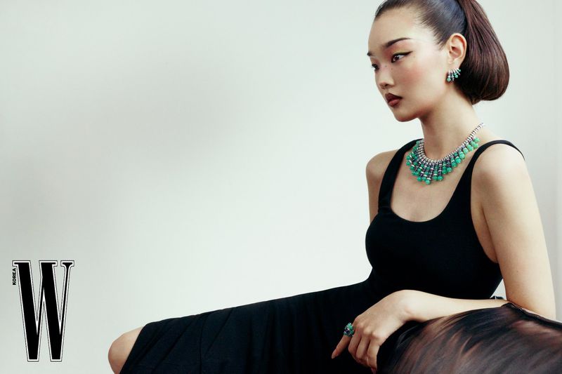 Model Bomi Youn wearing a black dress and green gemstone necklace for W Korea, photographed by Kim Hee June.