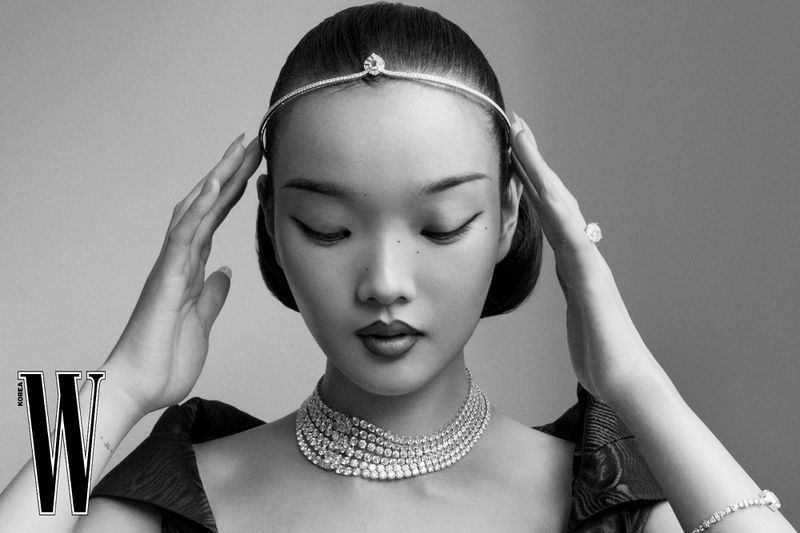 Monochrome fashion portrait of a model wearing a diamond tiara, layered tennis necklace, and bracelet for W Korea.