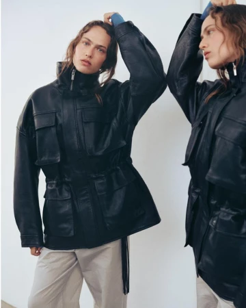 Model in black leather jacket and light trousers posing against a white background for Vagabond A/W 26 campaign.