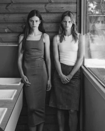 Two female models posing in a rustic wooden interior by a window for Study Magazine