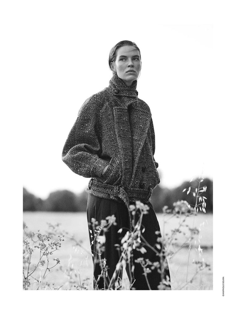 Model in textured belted wool jacket standing in an outdoor meadow for Elle Italia Love Notes fashion editorial.