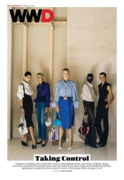 Five models posing on a wooden stage wearing tailored contemporary fashion outfits for WWD magazine cover.
