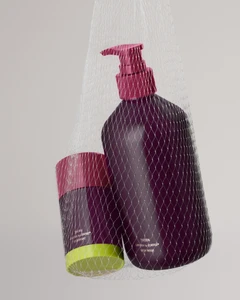 Two dark purple bottles with pink pump caps held inside a white mesh bag against a plain light grey background.