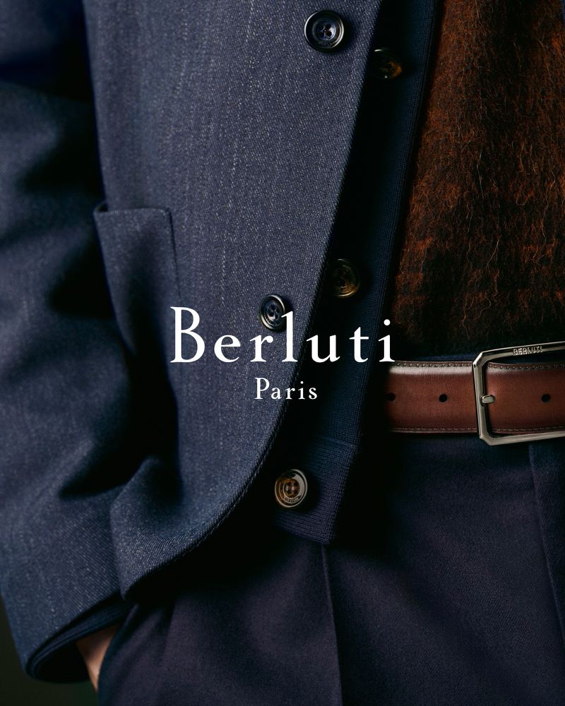 Close-up of a stylish Berluti denim suit with a brown belt and dark buttons, showcasing fashion and detail.