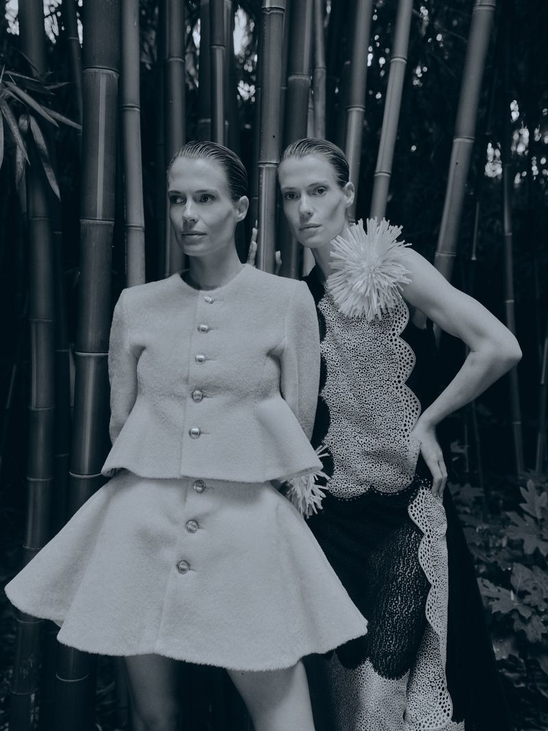 Lady Amelia Spencer and Lady Eliza Spencer posing outdoors among vertical bamboo stalks in designer fashion.