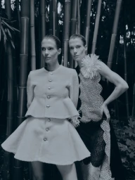 Lady Amelia Spencer and Lady Eliza Spencer posing outdoors among vertical bamboo stalks in designer fashion.