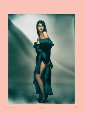 Sienna Spiro wearing an off-the-shoulder dark dress with teal ruffled accents in a magazine portrait for Billboard Magazine.