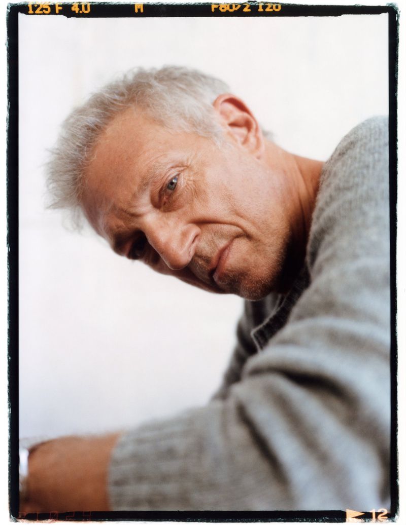 Portrait of actor Vincent Cassel wearing a grey sweater against a plain white background with visible film borders.