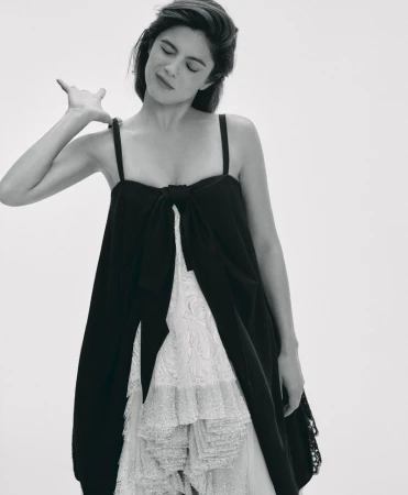 Monica Barbaro wearing a layered black and white dress against a plain white studio background for Telegraph Luxury.