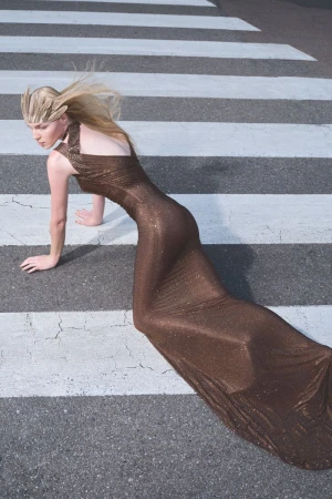 Model in a long brown glitter gown posing on a pedestrian crosswalk