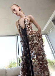 Model in embellished brown gown with black fringe details posing indoors near large windows for MFF Magazine New Perspectives editorial