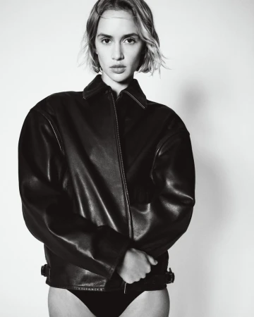Model wearing a black leather jacket against a neutral studio background