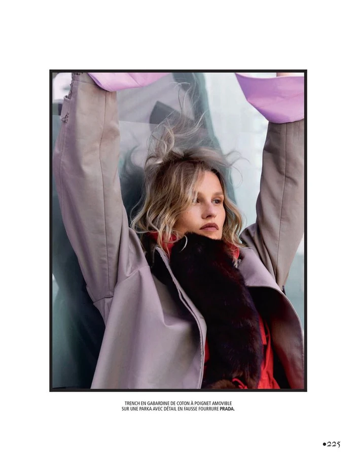 Model with arms raised wearing a grey coat and faux fur stole for Madame Figaro fashion editorial Us & Costumes