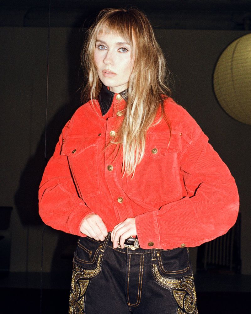 Veronika Slowikowska wearing a red corduroy jacket and dark pants for Nylon Magazine