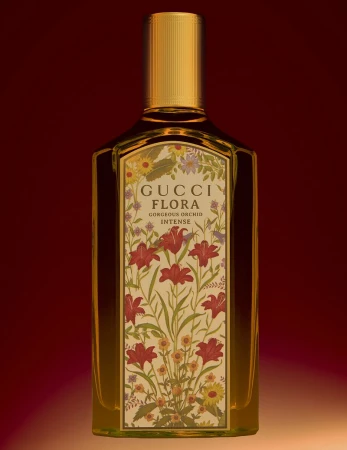 Gucci Flora Gorgeous Orchid Intense perfume bottle featuring a floral label against a rich dark red and amber gradient background.