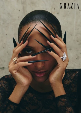 Close-up portrait of a model holding hands with long black pointed faux nails over face for Grazia Middle East wild at heart editorial
