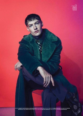 Model Roberto Sipos wearing a green coat and polka dot tie against a vibrant pink gradient background for GQ Turkey.