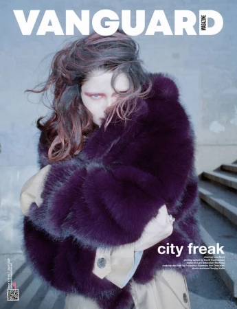 Vanguard Magazine cover featuring a model wrapped in a voluminous purple faux fur coat over a beige trench coat on concrete stairs.