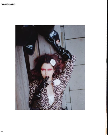 Woman in animal-print blazer poses with Umbro-branded clothing on a wood and stone surface, captured from a high angle.