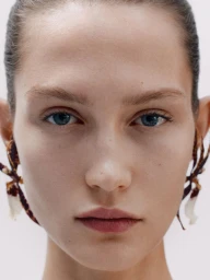 Close-up portrait of model Vika Evseeva wearing sculptural earrings for Giada FW26 campaign