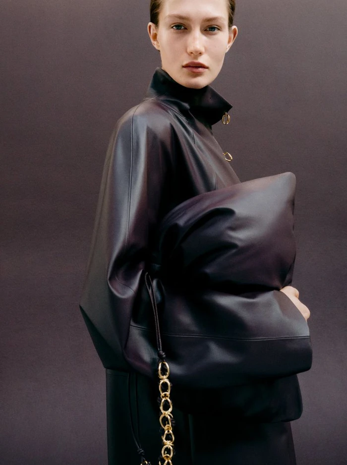 Model Vika Evseeva holding a large dark leather pouch for Giada FW26 campaign, photographed by Phil Engelhardt