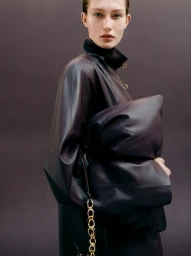 Model Vika Evseeva holding a large dark leather pouch for Giada FW26 campaign, photographed by Phil Engelhardt