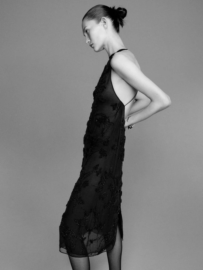 Model Vika Evseeva in a black embroidered dress against a grey studio background for Giada FW26 Campaign