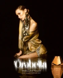 Bella Hadid in a draped metallic gold dress in water against a dark background for Orebella Vanilla's Touch