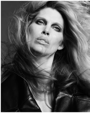 Close-up black and white portrait of model Iselin Steiro with windswept hair wearing a dark leather jacket.