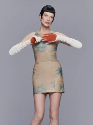 Model Kristen McMenamy wearing a patterned mini dress and long white gloves for Numero China Distance editorial