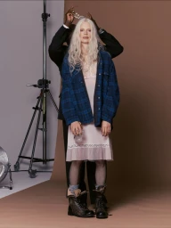 Kristen McMenamy with long white hair wearing a plaid overshirt over a pink slip dress for Numero China