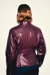Woman seen from behind wearing a plum quilted leather jacket against a neutral studio background
