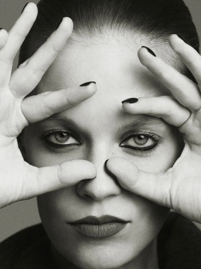 Close-up portrait of model Lexi Boling holding her hands up to frame her eyes, featuring dark nail polish and dramatic eye makeup for W Magazine China.