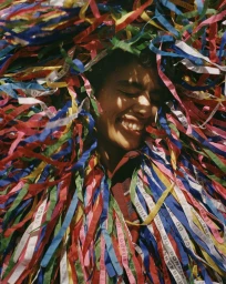 Smiling person surrounded by a dense cascade of colourful ribbon streamers for SZ Magazin Sueddeutsch Magazin editorial