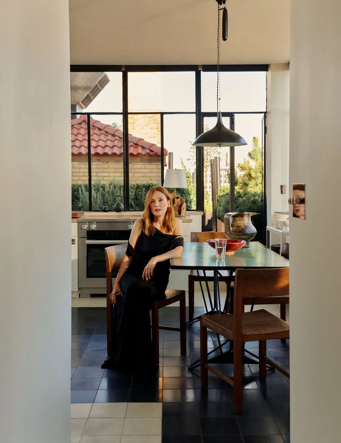 Julianne Moore seated at a dining table in a modern kitchen interior for Architectural Digest