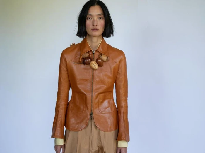 Model Lina Zhang wearing a brown leather jacket with a statement necklace for Holiday Magazine