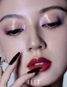 Close up beauty portrait of a woman with glossy red lips and iridescent purple eye makeup for Elle China