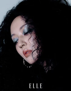 Close-up portrait of actress Ruixian He with voluminous black curly hair and shimmering metallic eyeshadow for Elle China.