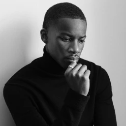 Black and white portrait of a black man wearing a black turtleneck and ring, shot by Jody Rogac for System Magazine.