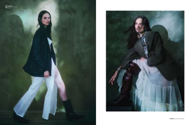 Model Kate McNamara posing in a structured jacket and skirt against a mottled green moody studio backdrop for Flaunt.