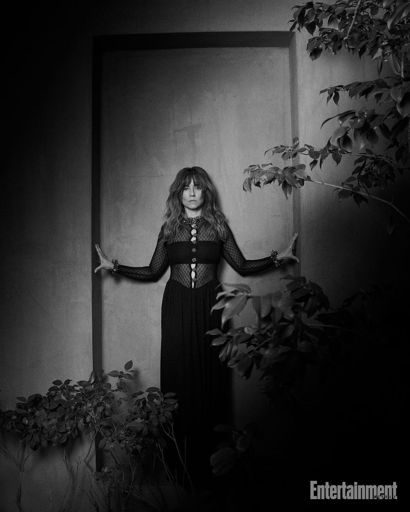 Portrait of Linda Cardellini standing within a dark alcove framed by leafy foliage for Entertainment Weekly.